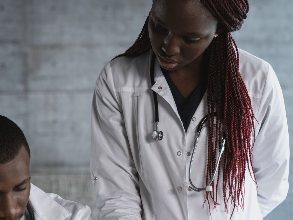 Deux professionnels de santé en blouse blanche travaillant côte à côte